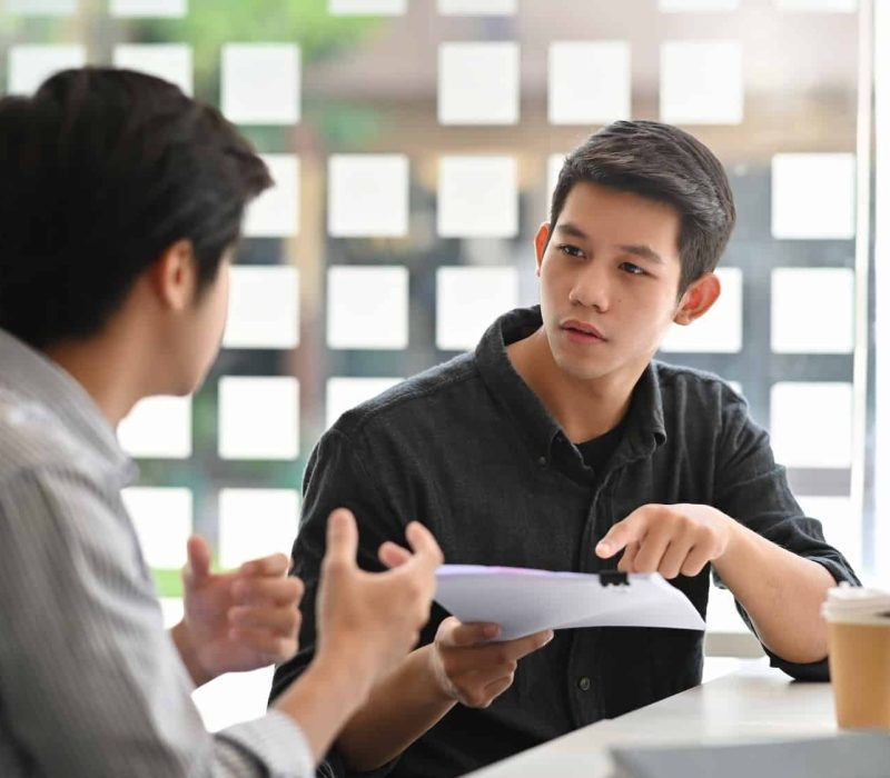 asian young man consulting with paper document on modern office .jpg